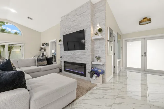 a living room with furniture a fireplace and a flat screen tv