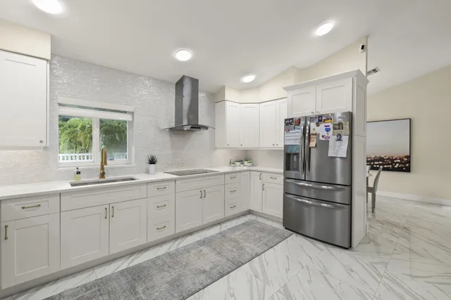 a kitchen with white cabinets and stainless steel appliances