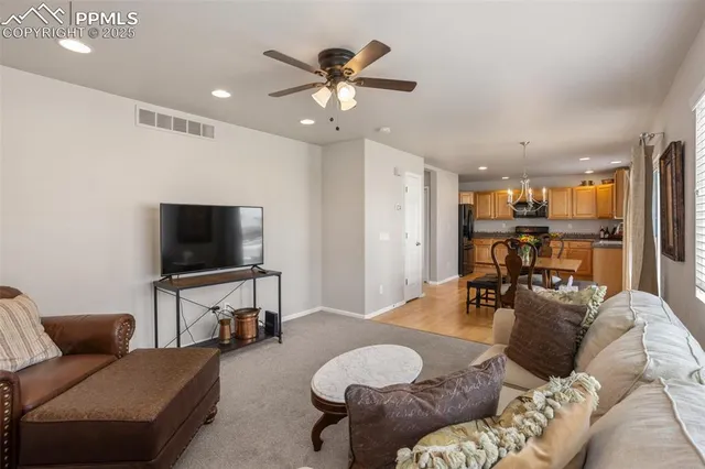 a living room with furniture and a flat screen tv with wooden floor