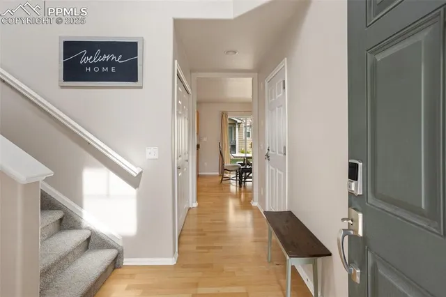 a view of a hallway with wooden floor and staircase