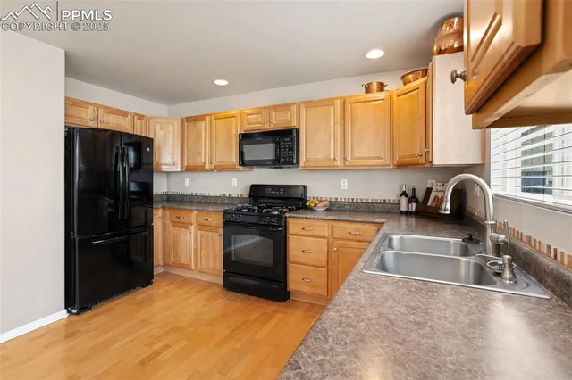 a kitchen with granite countertop a refrigerator and a sink