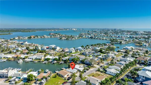 an aerial view of a city with lots of residential buildings and ocean view in back