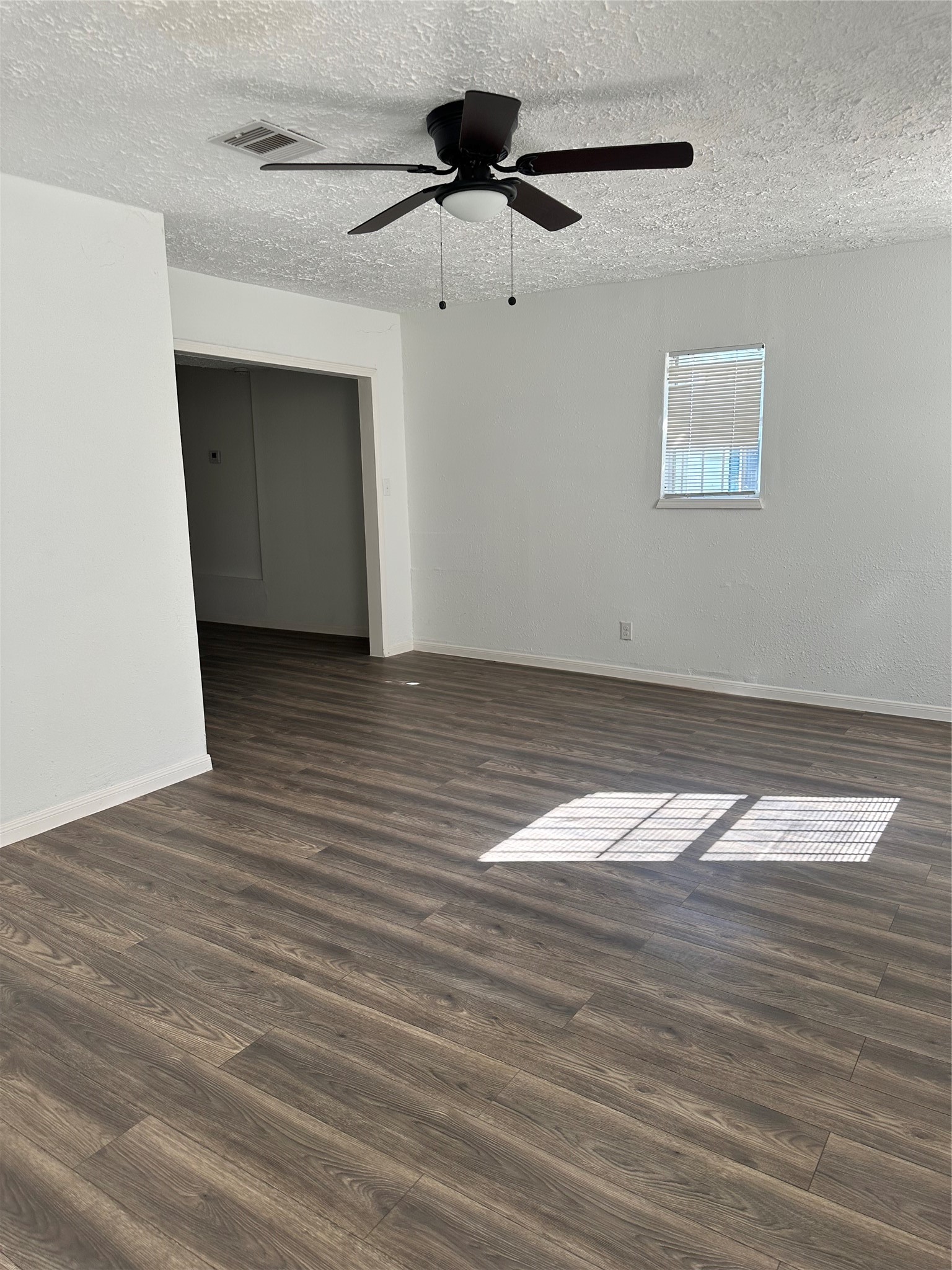 978 Ringold Street, Unit B Houston, TX 77088 - Photo 3 of 12 a view of an empty room with wooden floor and a ceiling fan