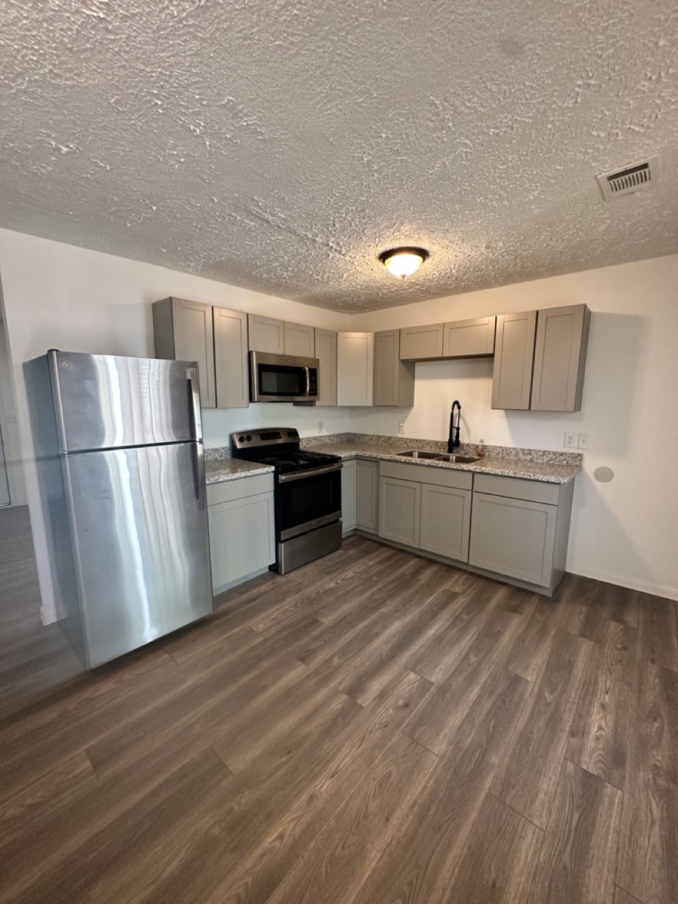978 Ringold Street, Unit B Houston, TX 77088 - Photo 8 of 12 a kitchen with stainless steel appliances granite countertop a refrigerator a stove top oven a sink and dishwasher