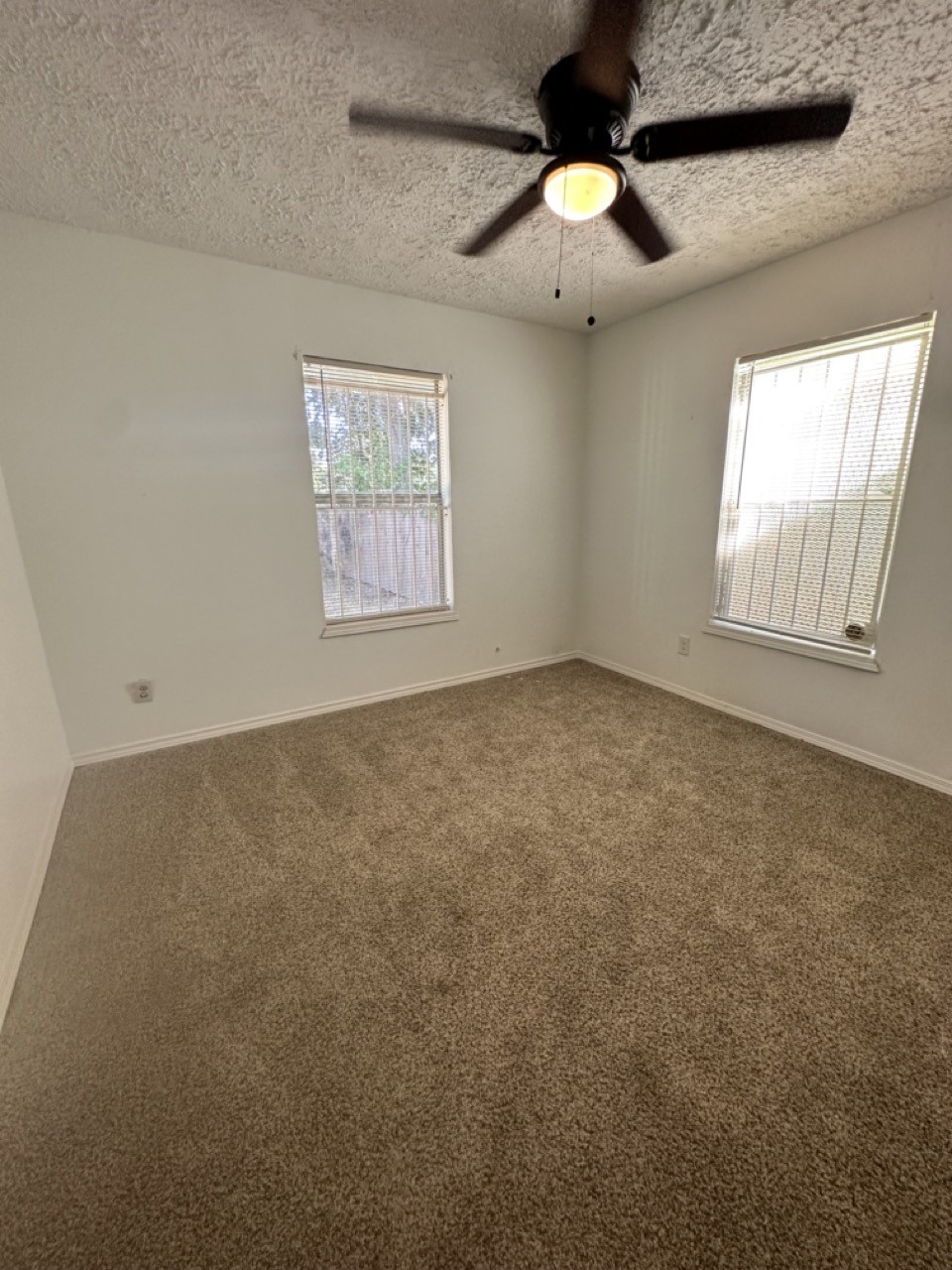 978 Ringold Street, Unit B Houston, TX 77088 - Photo 9 of 12 an empty room with windows and fan
