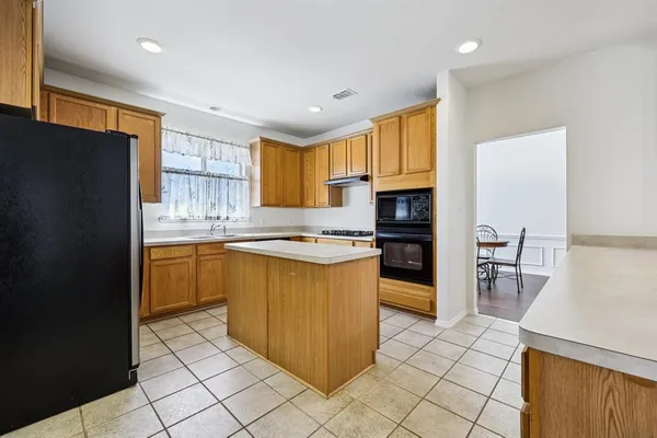 a kitchen with stainless steel appliances granite countertop a stove a sink dishwasher and a refrigerator