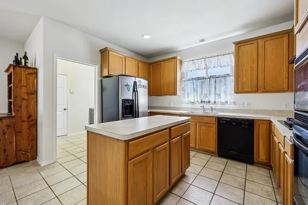 a kitchen with granite countertop cabinets stainless steel appliances and a window