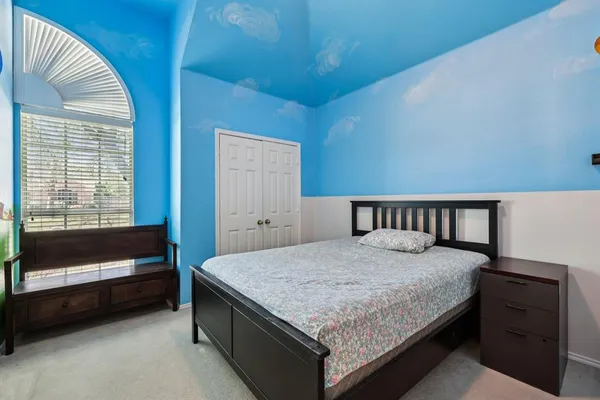 a bedroom with a bed and a window