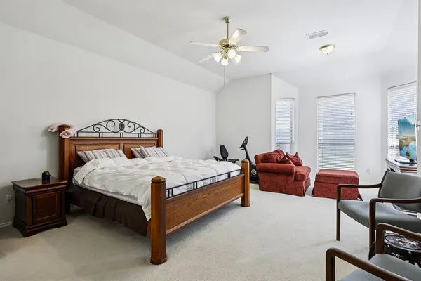 a bedroom with bed a chair and a chandelier