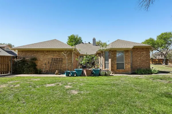 a view of a house with backyard and a tree