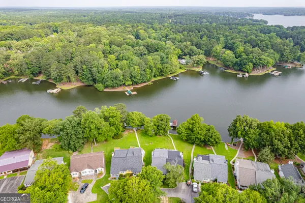 an aerial view of a house with a yard and a large tree