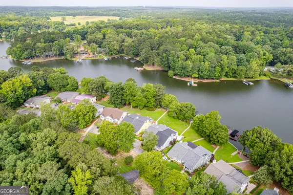 an aerial view of a house with a yard and a large tree