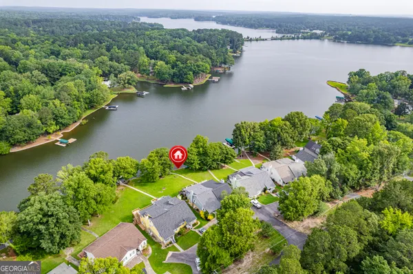 an aerial view of a house with a yard and lake view