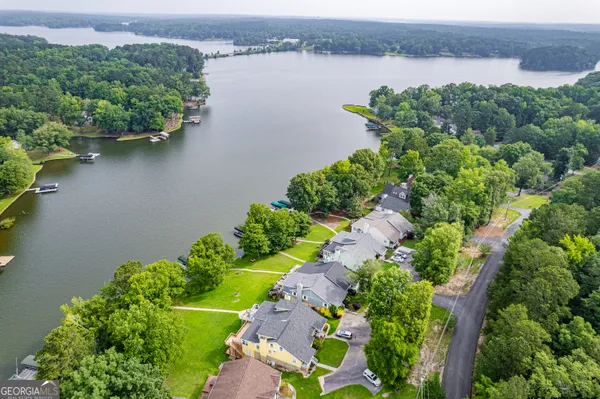 an aerial view of a house with a yard and lake view