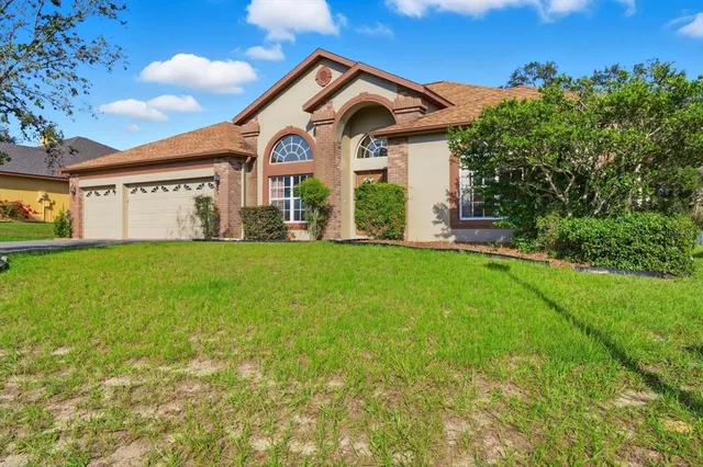 a view of a house with a big yard and large trees