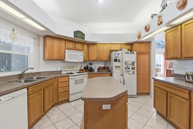 a kitchen with stainless steel appliances granite countertop a sink stove refrigerator and cabinets