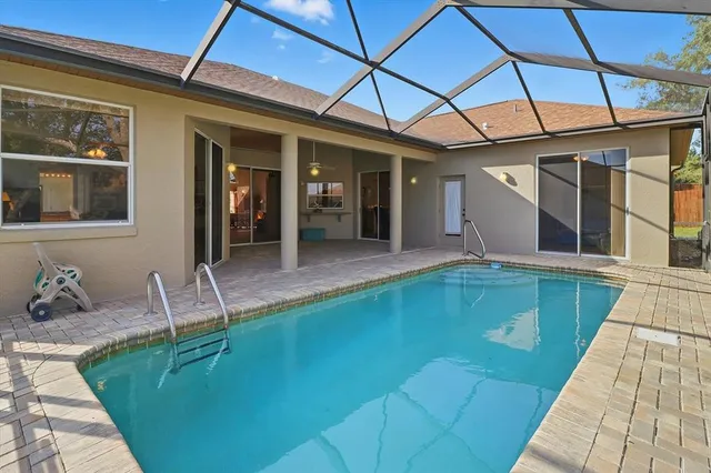 a front view of a house with swimming pool and furniture