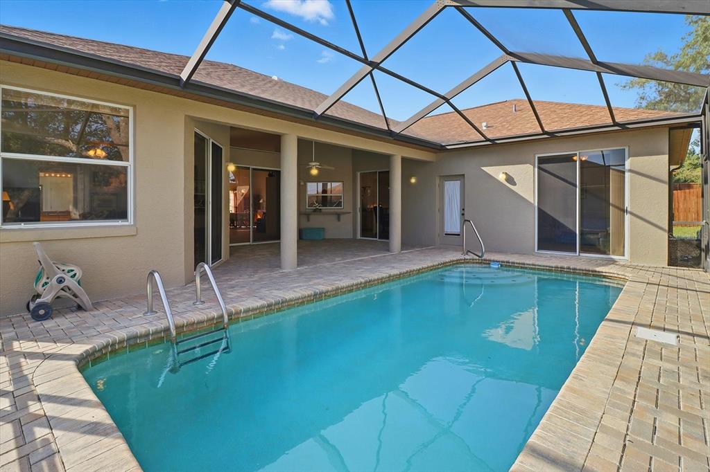 63 North Youngtree Point Lecanto, FL 34461 - Photo 2 of 48 a front view of a house with swimming pool and furniture