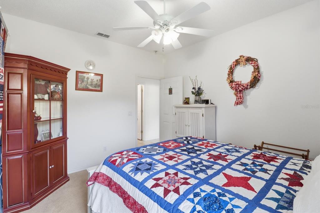 63 North Youngtree Point Lecanto, FL 34461 - Photo 25 of 48 a bedroom with a bed and a chandelier