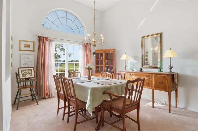 a dining room with wooden floor a chandelier a wooden table and chairs