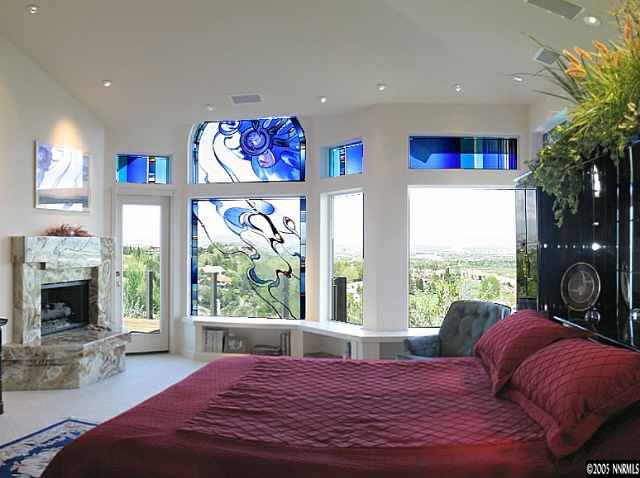6107 Carriage House Way Reno, NV 89519 - Photo 2 of 9 a bedroom with a large bed and a fireplace