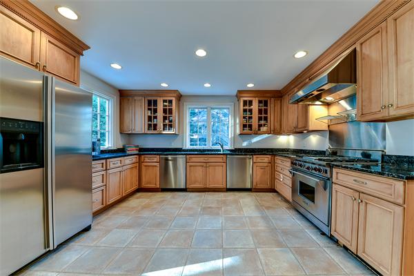 24 Hillside Road Wellesley, MA 02481 - Photo 7 of 17 a large kitchen with stainless steel appliances granite countertop a large stove top oven and cabinets