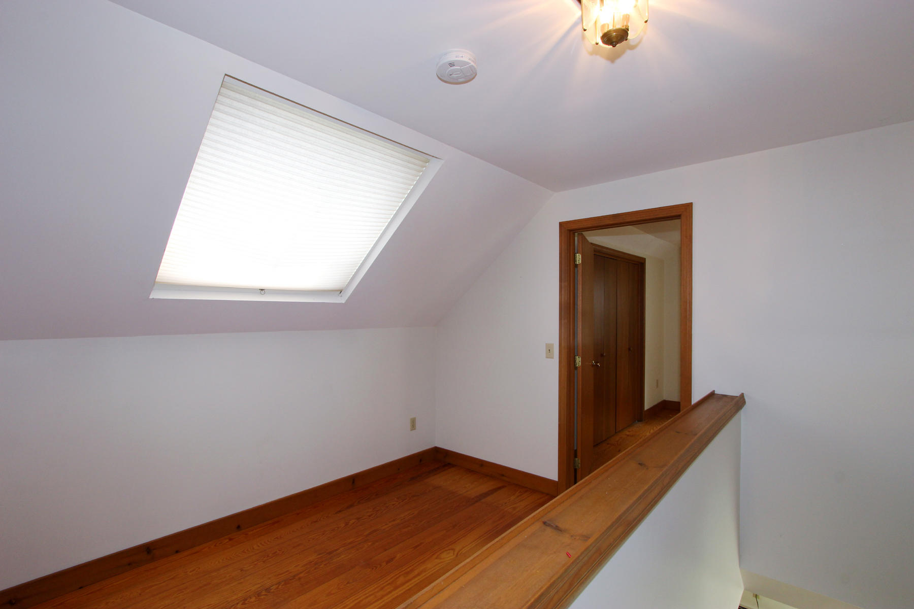 216 Cathedral Road Brewster, MA 02631 - Photo 23 of 56 an empty room with wooden floor and windows
