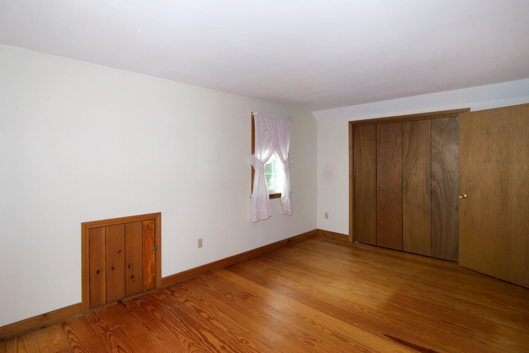 216 Cathedral Road Brewster, MA 02631 - Photo 26 of 56 an empty room with wooden floor and windows