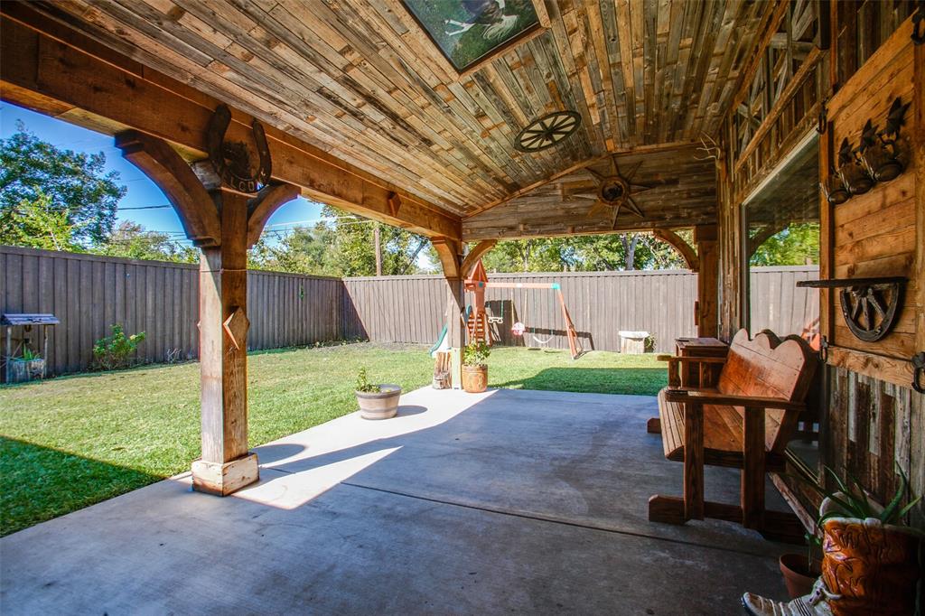 a view of backyard with table and chairs and wooden fence