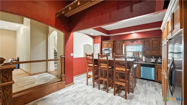 a kitchen with stainless steel appliances granite countertop a stove top oven a sink and dishwasher