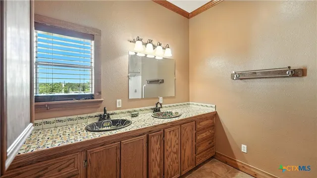 a bathroom with a double vanity sink mirror and bathtub