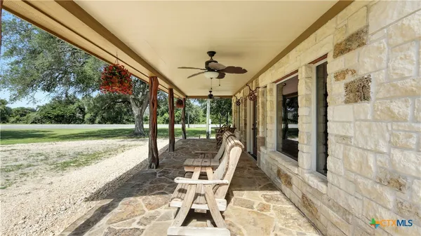 a view of a porch with furniture and a yard