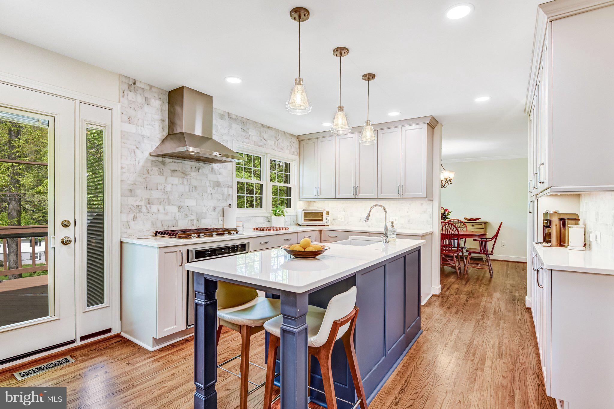 6600 Kensal Court Springfield, VA 22152 - Photo 20 of 43 a kitchen with stainless steel appliances a stove a sink a center island and a wooden floor