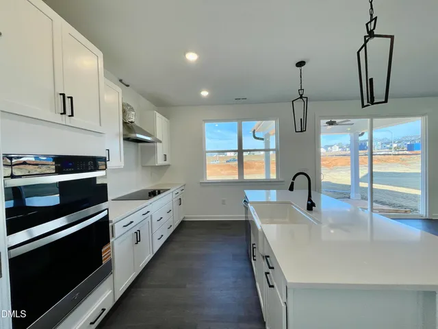 a kitchen with stainless steel appliances a sink a stove and a wooden floors