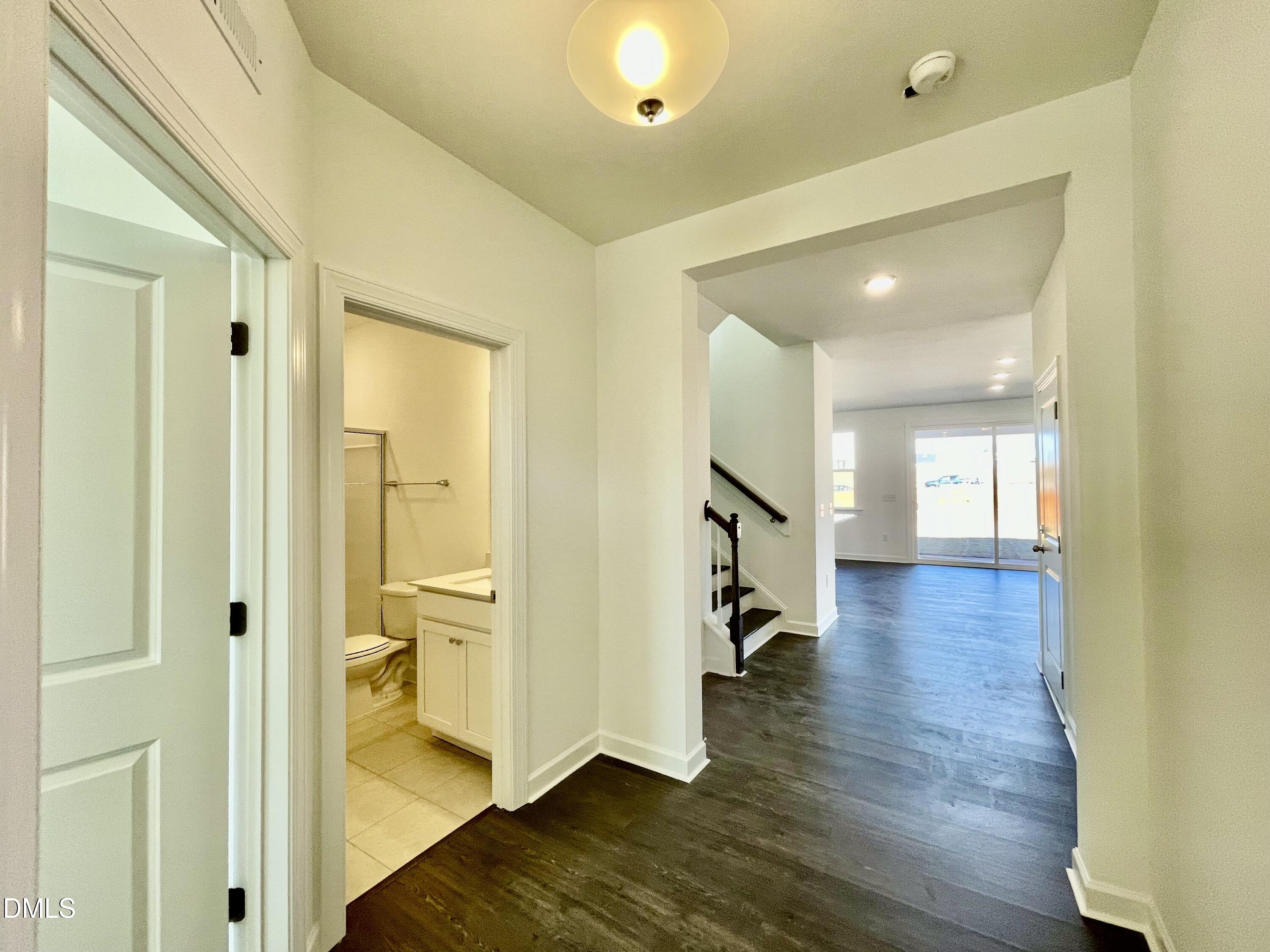 229 Sprenger Street Garner, NC 27529 - Photo 9 of 37 a view of a hallway with wooden floor and a bathroom
