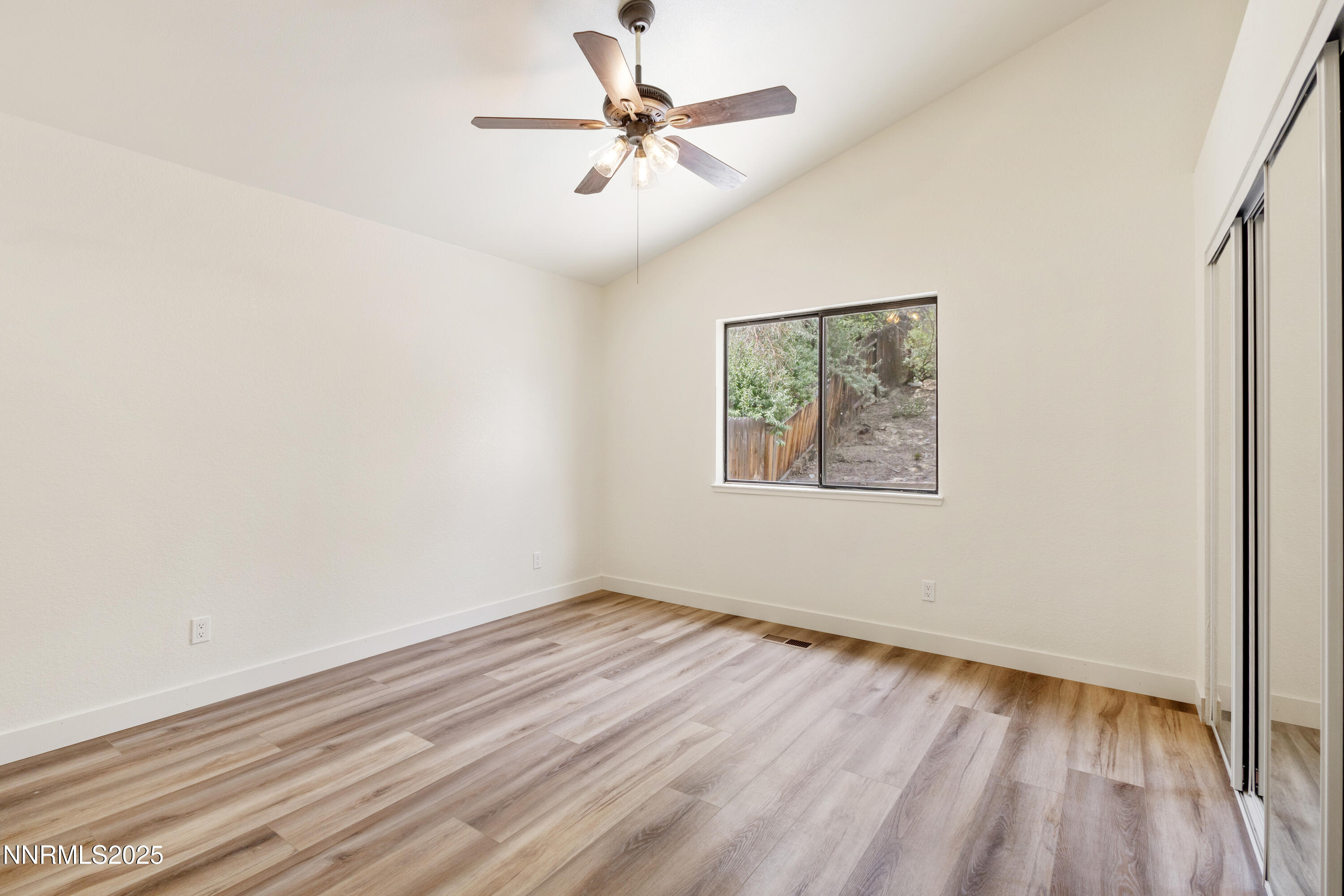 5809 Sydney Court Reno, NV 89523 - Photo 11 of 28 an empty room with wooden floor chandelier fan and windows