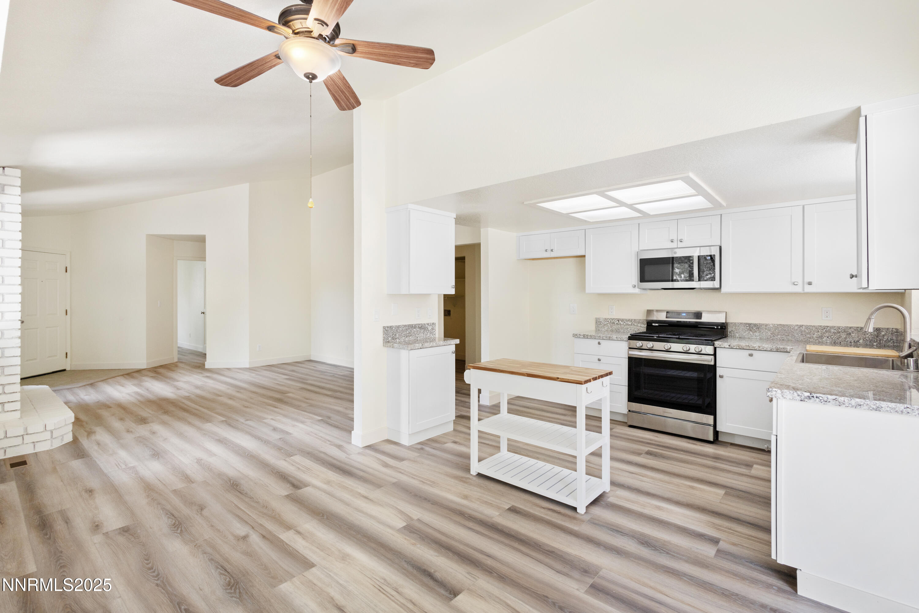 5809 Sydney Court Reno, NV 89523 - Photo 6 of 28 a kitchen with a refrigerator and white cabinets