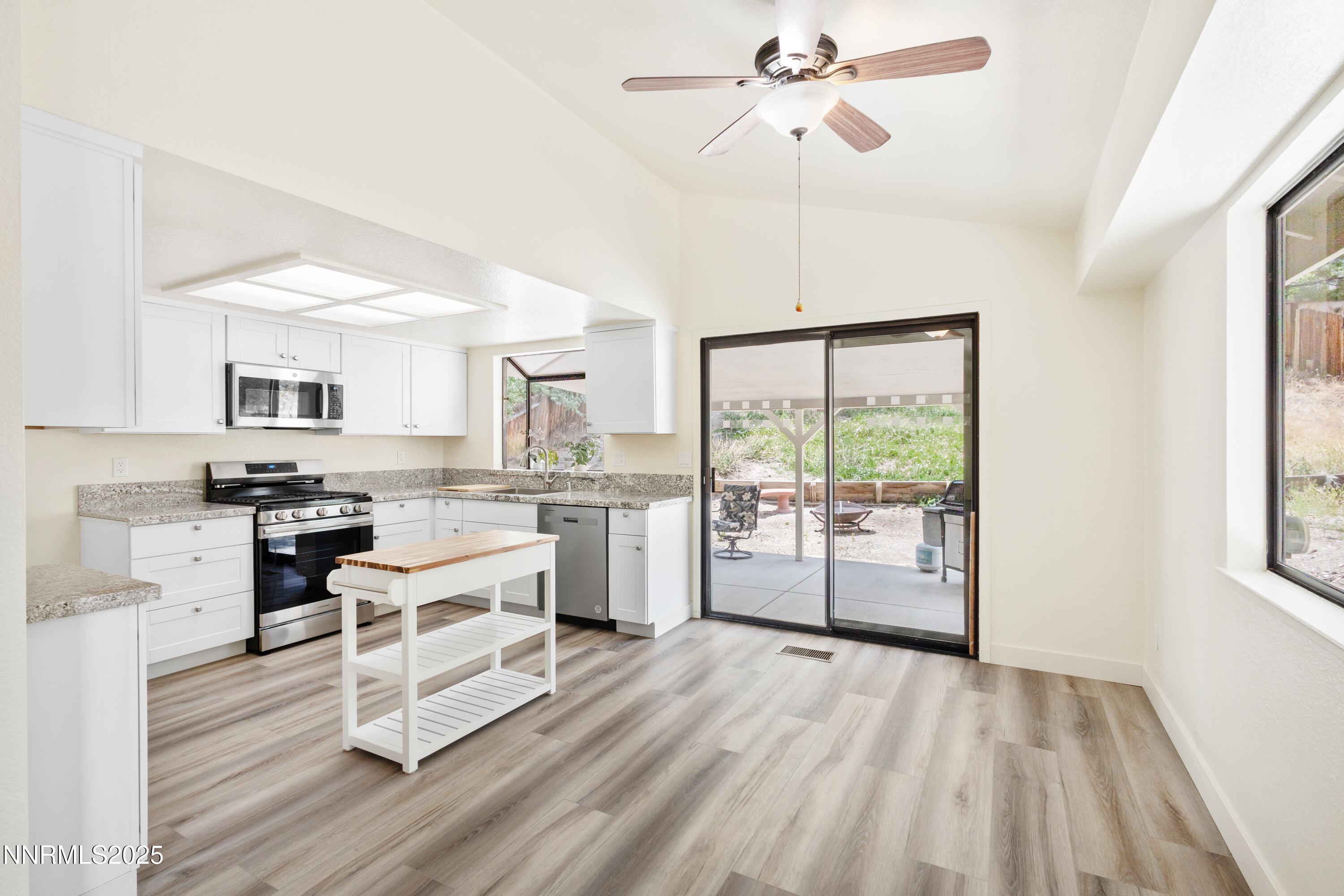 5809 Sydney Court Reno, NV 89523 - Photo 7 of 28 a kitchen with white cabinets and wooden floor