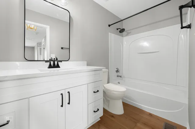 a bathroom with a bathtub shower sink vanity and toilet