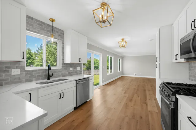 a kitchen with a sink and wooden floor