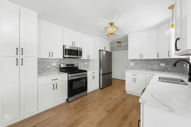 a kitchen with granite countertop a refrigerator stove top oven and sink