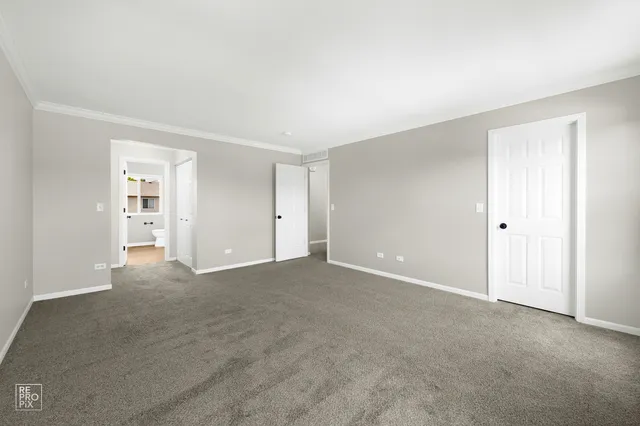 a view of an empty room with closet and a window
