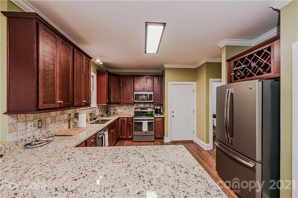 154 Morrison Hill Road Davidson, NC 28036 - Photo 9 of 23 a kitchen with stainless steel appliances granite countertop a refrigerator a stove and a sink with wooden cabinets