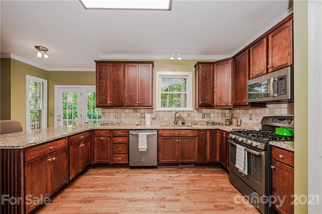 154 Morrison Hill Road Davidson, NC 28036 - Photo 10 of 23 a kitchen with stainless steel appliances granite countertop wooden cabinets a sink and a stove