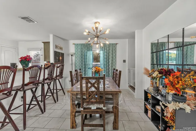 a view of a dining room with furniture and chandelier