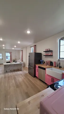 a large kitchen with stainless steel appliances a large counter top and a stove