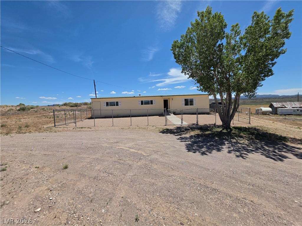 A quaint residence nestled in a natural landscape, surrounded by a chain link fence.