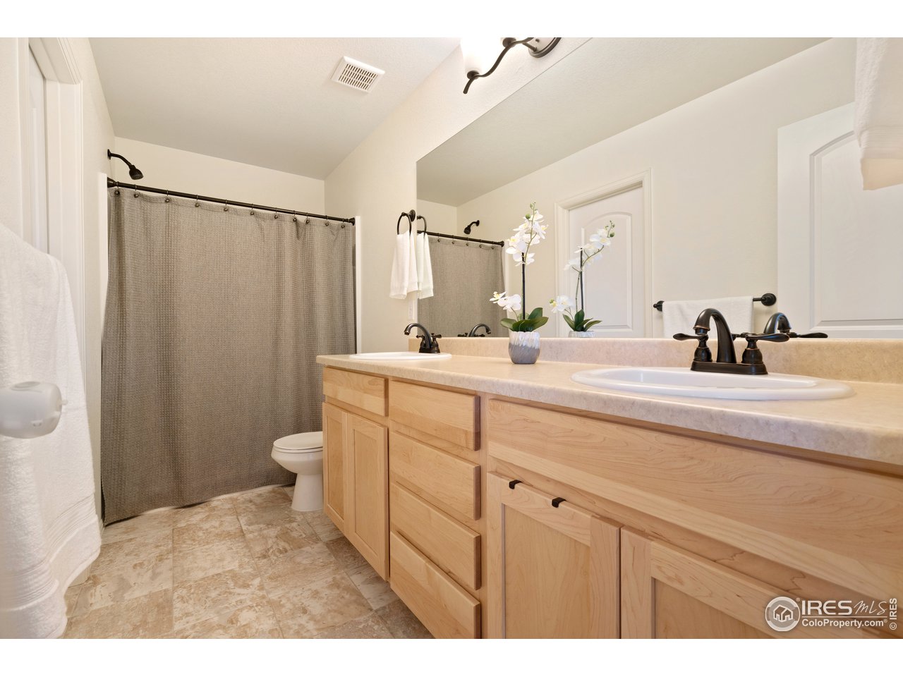 8705 13th St Road Greeley, CO 80634 - Photo 22 of 40 Attached full bathroom for the main bedroom has dual sinks, large mirror and large walk in closet access.