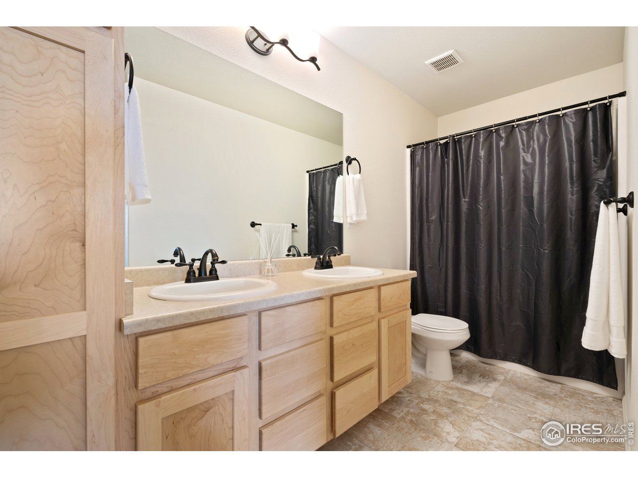 8705 13th St Road Greeley, CO 80634 - Photo 28 of 40 Shared full bathroom located upstairs has dual sinks and extra storage.