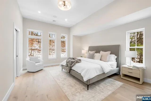 a spacious bedroom with a bed and glass walk in closet